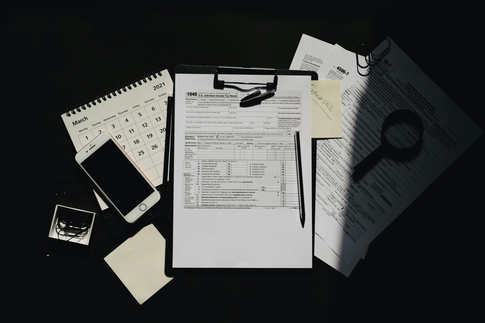 Services 5 Flat lay of tax documents, calendar, and smartphone on a dark surface, symbolizing tax preparation.
